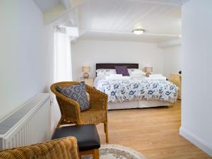 a bedroom with a bed and a chair in it at 3 Horse Pool Road in Laugharne