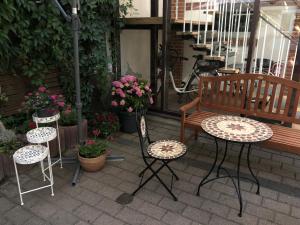 a patio with two chairs and a bench and flowers at Central-Hotel Torgau in Torgau