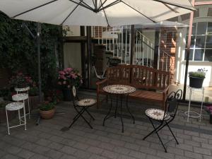 eine Terrasse mit Tisch, Stühlen und Sonnenschirm in der Unterkunft Central-Hotel Torgau in Torgau