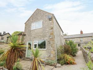 an image of a stone house with plants at Jasmine Cottage in Bakewell