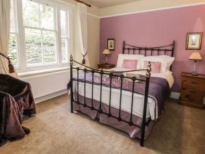 1 dormitorio con 1 cama con paredes moradas en Rowan Cottage, en Grasmere