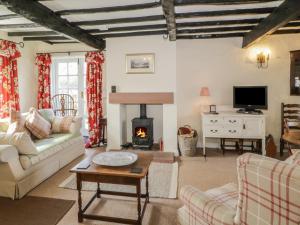 a living room with a couch and a fireplace at Blacksmiths Cottage in Pooley Bridge