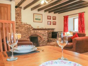 comedor con mesa y 2 copas de vino en Low Garth Cottage, en Penruddock