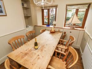 a dining room with a wooden table and chairs at Puddle Duck Cottage in Spark Bridge