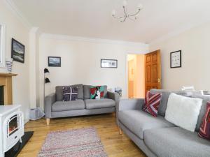 a living room with two couches and a fireplace at Siskin in Keswick +2 photos