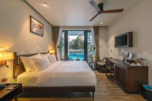 Habitación de hotel con cama y piscina en Volar de Faifo Villa, en Hoi An