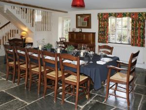 a dining room with a blue table and chairs at The Coach House in Lydford