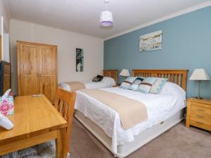 - une chambre avec 2 lits et une table en bois dans l'établissement Richmond Cottage, à Malton