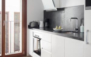 a kitchen with white cabinets and a sink and a window at Apartment Santa Cruz Suite TI105 in Palma de Mallorca