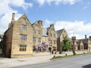 an old stone building with purple flowers in front of it at Willow Lodge in Cleeve Prior