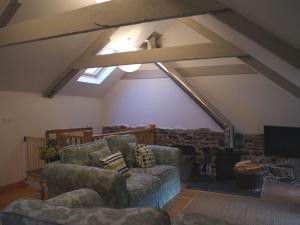 a living room with two couches and a projection screen at The Stone Barn Cottage in Holne