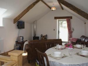 a living room with a table and a couch at Bowbeer Barn in Drewsteignton