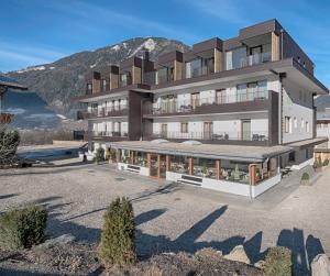 een groot gebouw met een berg op de achtergrond bij Hotel Mair in Campo Tures