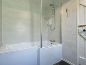 La salle de bains blanche est pourvue d'une douche et d'une baignoire. dans l'établissement Little Week Cottage, à Bridestowe 9 autres photos