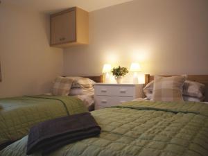 une chambre avec deux lits et une commode dans l'établissement The Stone Barn Cottage, à Holne