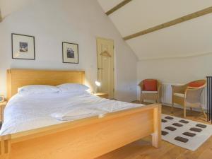 a bedroom with a large bed with a wooden headboard at The Bakehouse in Gidleigh +6 photos