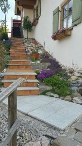 a set of stairs in front of a house with flowers at Ferienhaus Allgäu in Nesselwang