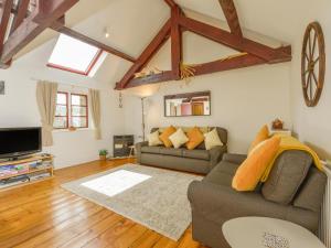 a living room with a couch and a tv at Ludgate Cottage in Bovey Tracey
