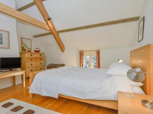 een slaapkamer met een groot wit bed en een bureau bij The Bakehouse in Gidleigh