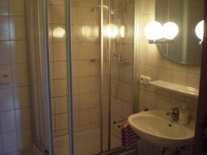 a bathroom with a shower and a sink at Ferienhaus Allgäu in Nesselwang