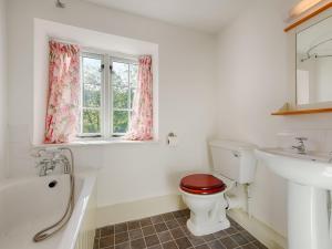 a bathroom with a toilet and a tub and a sink at Barn Cottage in Hawkridge +22 photos