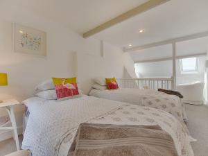 2 łóżka w pokoju z białymi ścianami w obiekcie 1 The Quay w mieście Lympstone