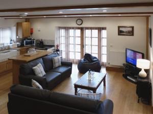 a living room with a couch and a table at Hiscox Cottage in Southleigh