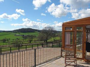 a house with a deck with a view of a field at Hiscox Cottage in Southleigh