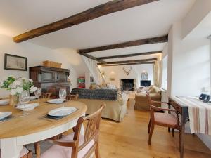 a dining room with a table and a living room at Barn Cottage in Hawkridge