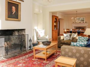 a living room with a couch and a fireplace at Sandridge Barton in Stoke Gabriel
