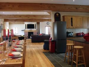 The Barn في Southleigh: مطبخ وغرفة معيشة مع طاولة طويلة مع أطباق عليها