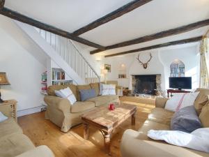 a living room with two couches and a table at Barn Cottage in Hawkridge