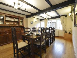a dining room with a wooden table and chairs at Lower Wadden Farmhouse and Annexe in Southleigh