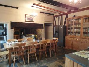 a kitchen with a large wooden table and chairs at Hornshayne Farmhouse in Northleigh