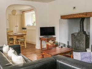 a living room with a couch and a tv at Alice Cottage in Minehead