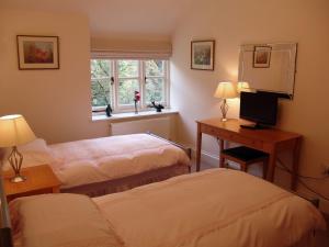 a room with two beds and a television and a window at Glenview in Lynton