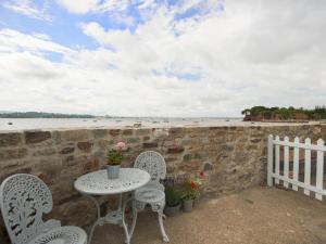 a table and chairs on a patio near the beach at 1 The Quay in Lympstone