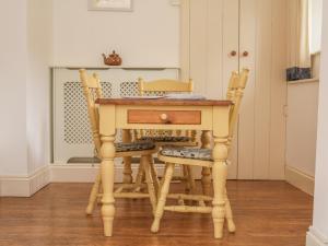 a wooden table with two chairs and a desk at Alice Cottage in Minehead