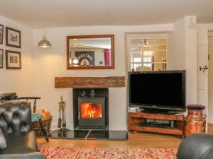 a living room with a fireplace and a flat screen tv at 11 The Green in Budleigh Salterton