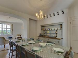 une salle à manger avec une table, des chaises et un lustre dans l'établissement The Mount, à Dulverton