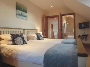 um quarto com uma cama grande com almofadas em The Barn em Southleigh