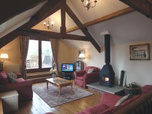 a living room with a wood stove in a room at The Cottage in Sampford Courtenay