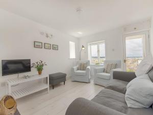 a living room with a couch and a tv at 1 The Quay in Lympstone