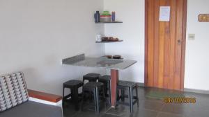 una mesa y taburetes en una habitación con encimera en Chalés e suite Ilhabela, en Ilhabela