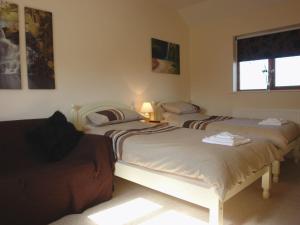 a bedroom with two beds and a window at Barn View in Welcombe