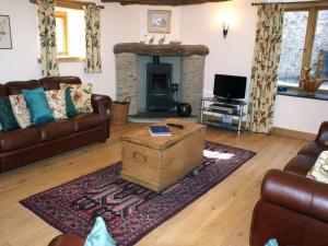 a living room with a couch and a fireplace at The Hay Barn in Halwell