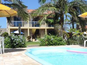 un complexe avec une piscine en face d'un bâtiment dans l'établissement Pousada Don Fernandes, à Torres