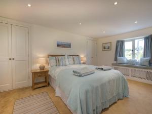 een slaapkamer met een bed met twee handdoeken erop bij Junket Cottage in Newton Ferrers