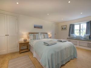 a bedroom with a bed with two towels on it at Junket Cottage in Newton Ferrers