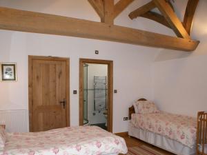 um quarto com 2 camas e um tecto de madeira em The Hay Barn em Halwell